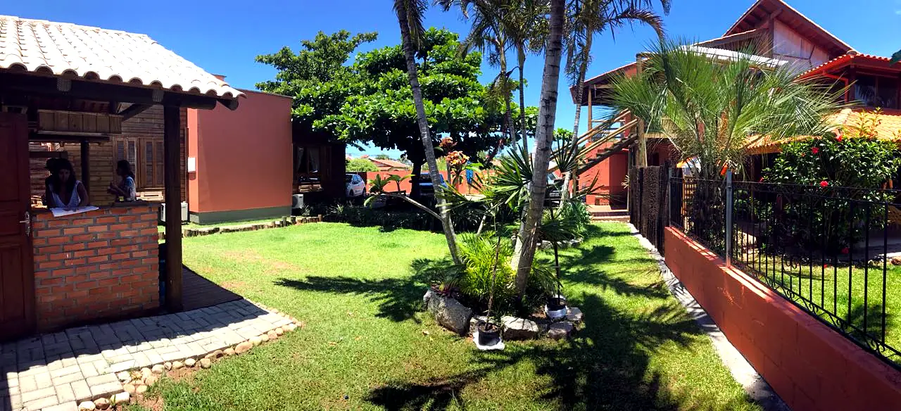 Jardim e recepção da Campeche Lofts em dia de sol
